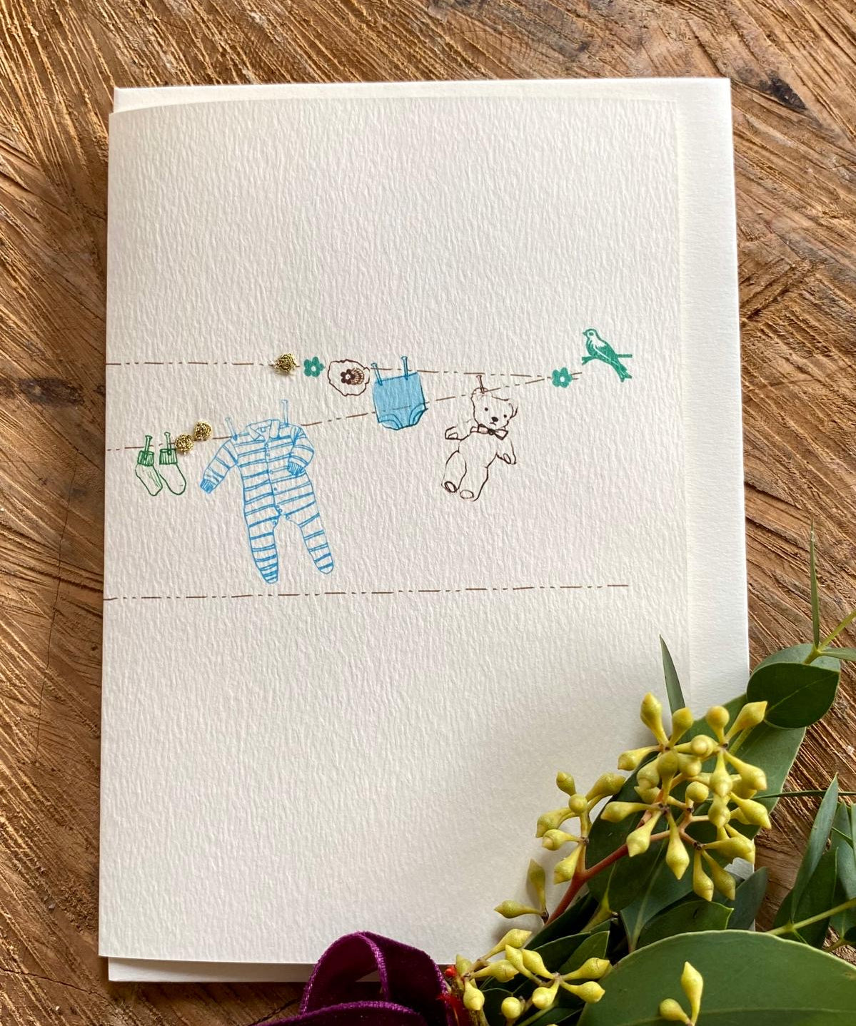 Beautiful handmade Baby Boy Washing Line card by Elena Deshmukh. Printed on luxury sustainable textured card with delicate artisan detail.