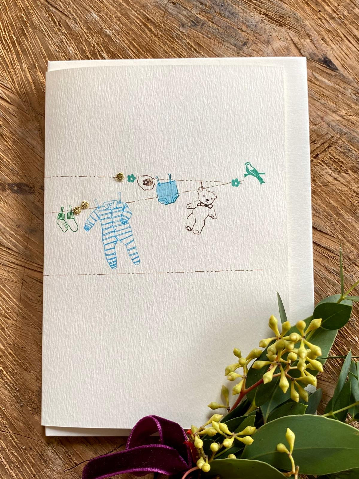 Beautiful handmade Baby Boy Washing Line card by Elena Deshmukh. Printed on luxury sustainable textured card with delicate artisan detail.