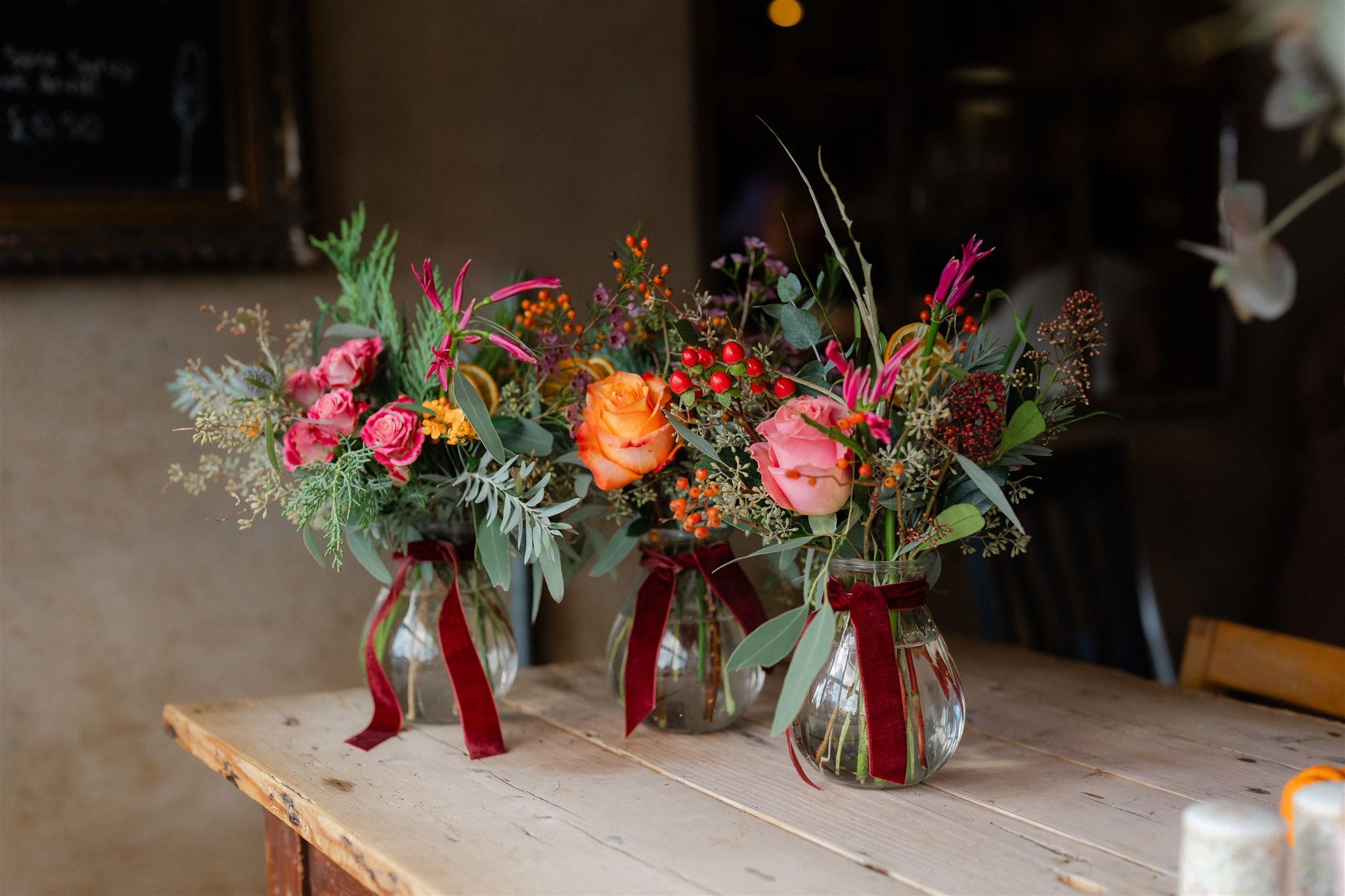The Enchanted Forest Table Bottles are a trio of festive flower-filled bud vases, hand-arranged for Christmas tables, mantelpieces and seasonal gifting.
