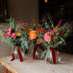 The Enchanted Forest Table Bottles are a trio of festive flower-filled bud vases, hand-arranged for Christmas tables, mantelpieces and seasonal gifting.