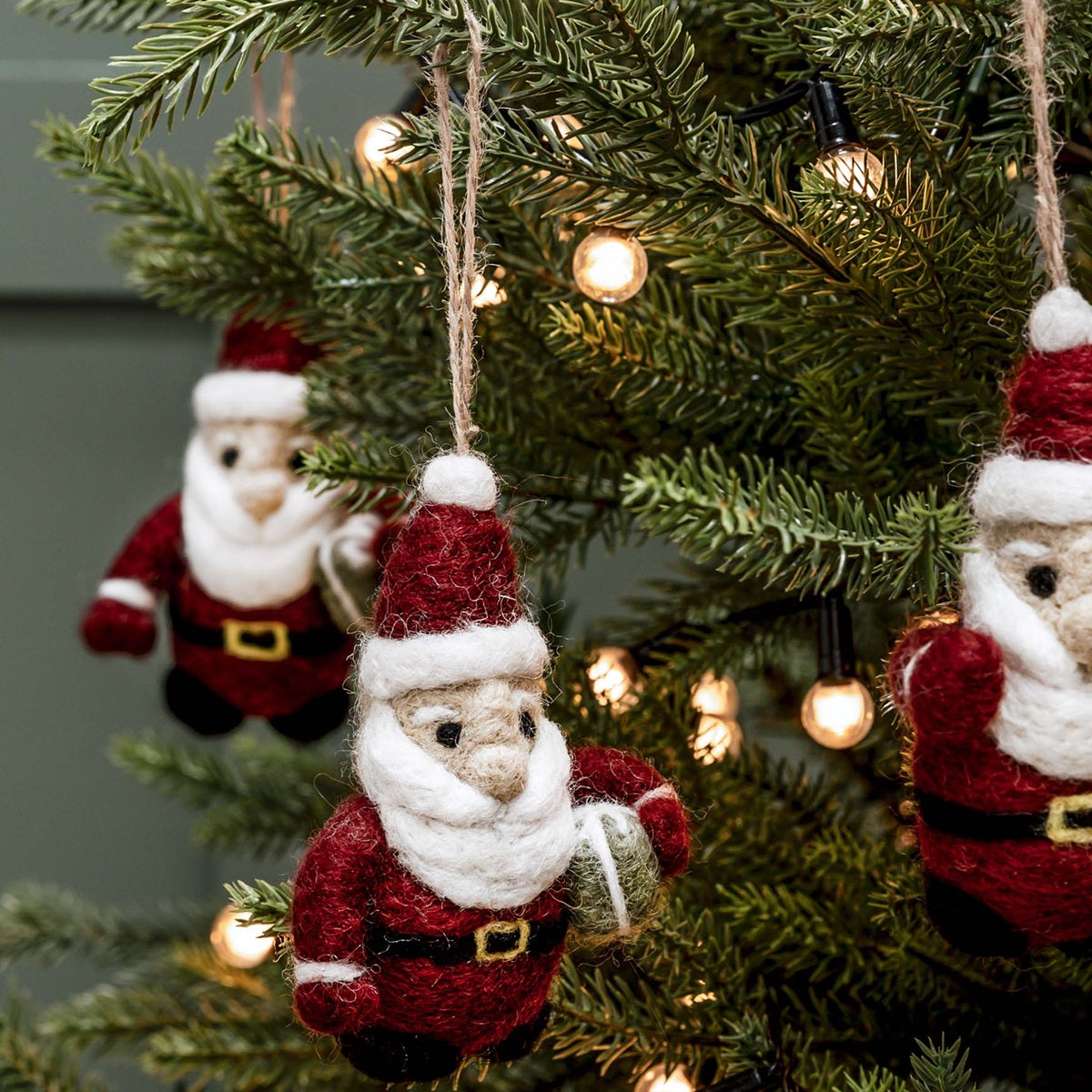 Berry red felt Santa Christmas tree decoration carrying a green present