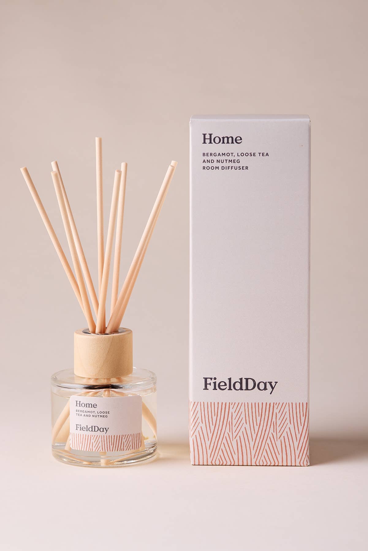 FieldDay Home reed diffuser with bergamot, loose tea and nutmeg in a glass bottle with wooden cap and natural reeds.