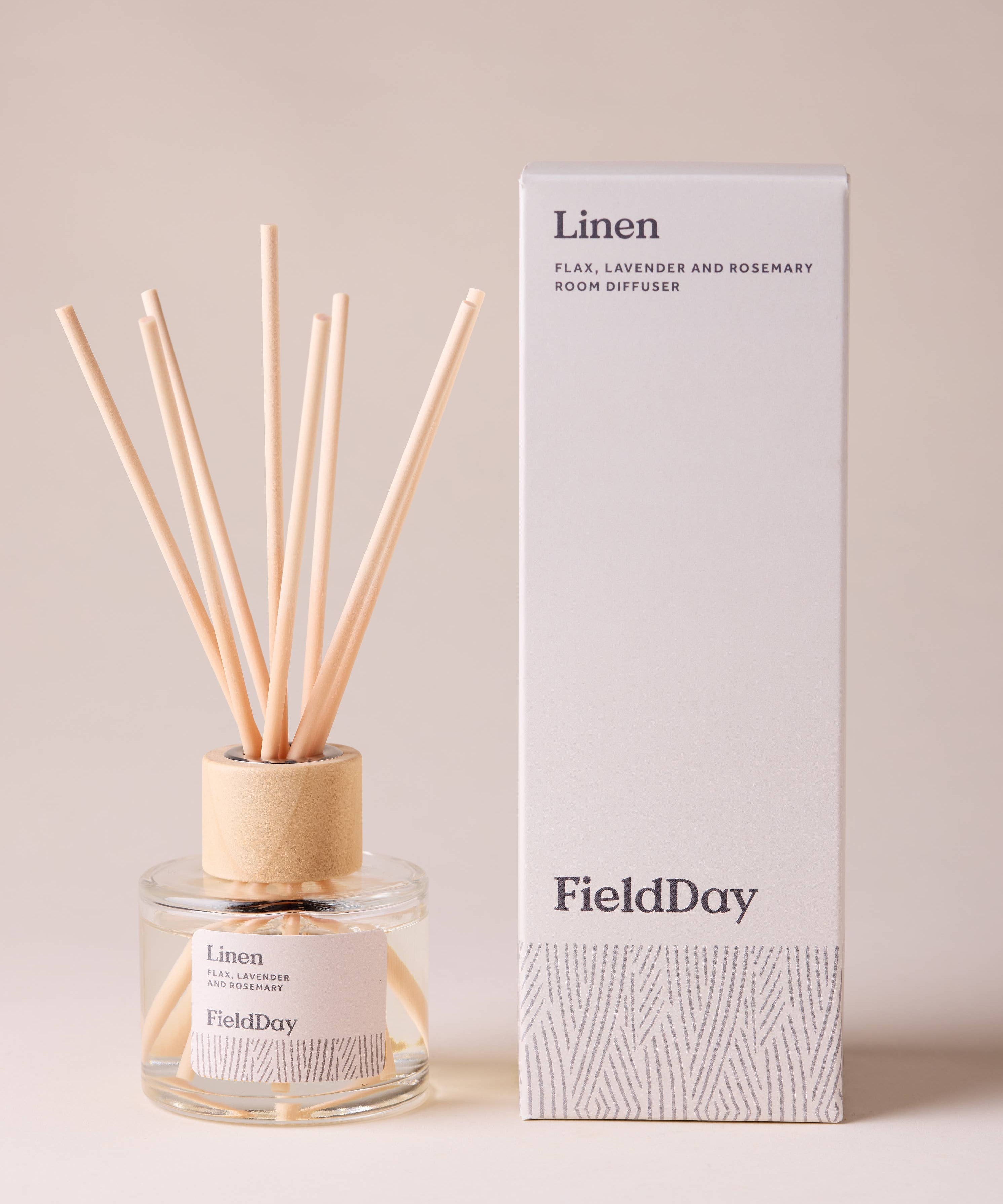 FieldDay Linen reed diffuser with flax, lavender and rosemary fragrance in a glass bottle with wooden cap and natural reeds.