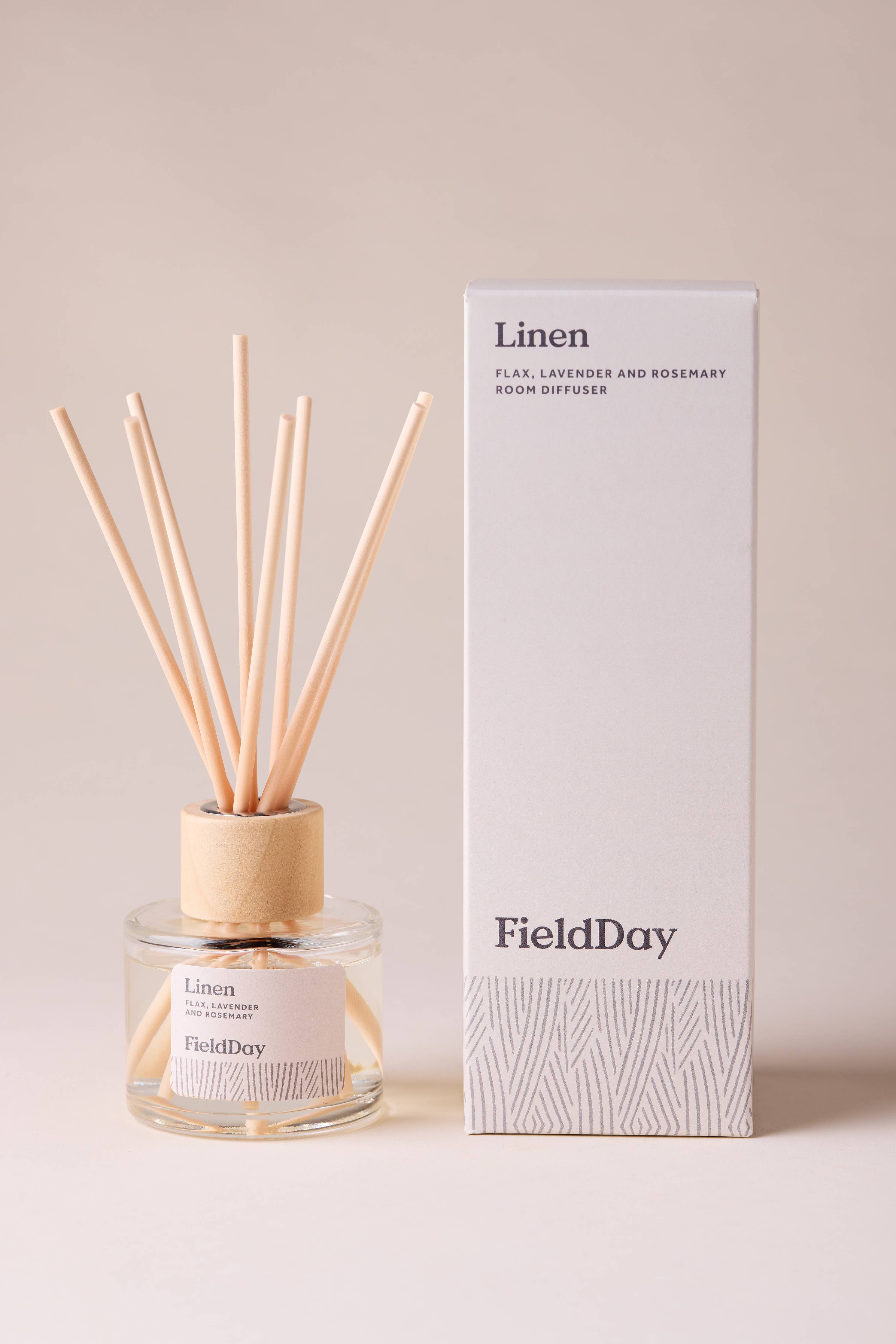 FieldDay Linen reed diffuser with flax, lavender and rosemary fragrance in a glass bottle with wooden cap and natural reeds.