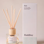 FieldDay Sea reed diffuser with salt air, lemon and sandalwood in a glass bottle with wooden cap and natural reeds.