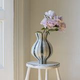 Green striped decorative vase with rounded body and fluted flared neck