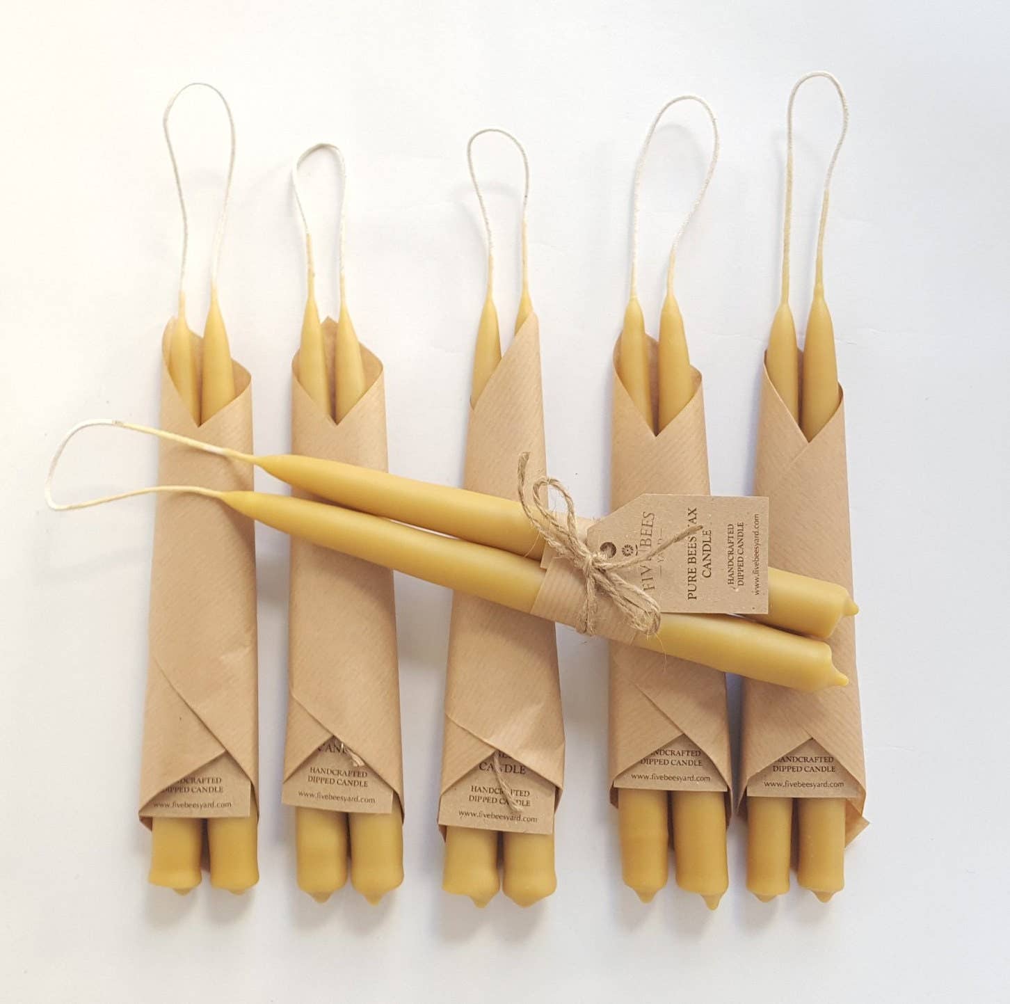Set of two natural beeswax taper candles, traditionally hand-dipped with unbleached cotton wicks, approximately 20cm tall.