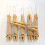 Set of two natural beeswax taper candles, traditionally hand-dipped with unbleached cotton wicks, approximately 20cm tall.