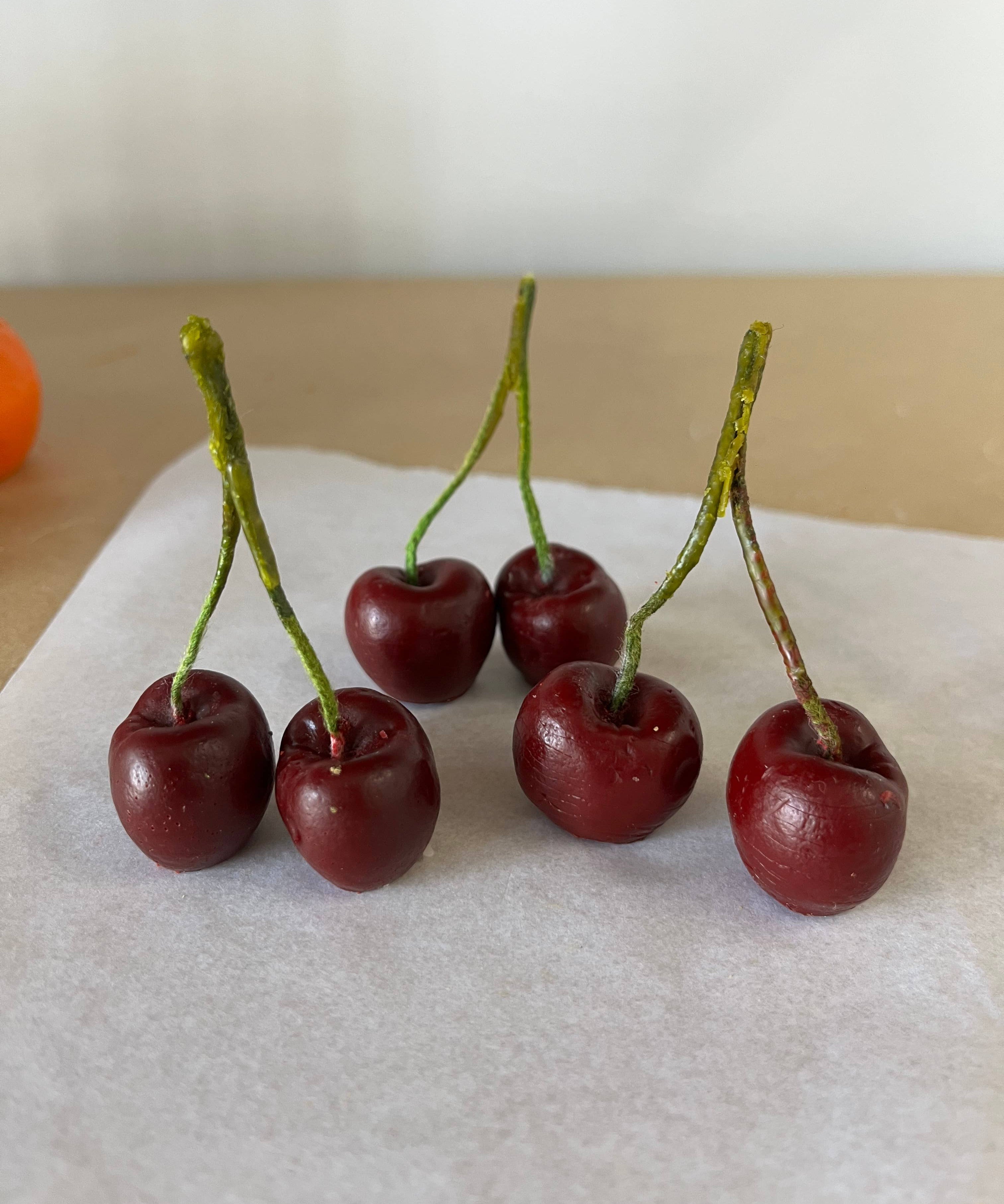 Handmade cherry-shaped candle crafted from 100% natural beeswax