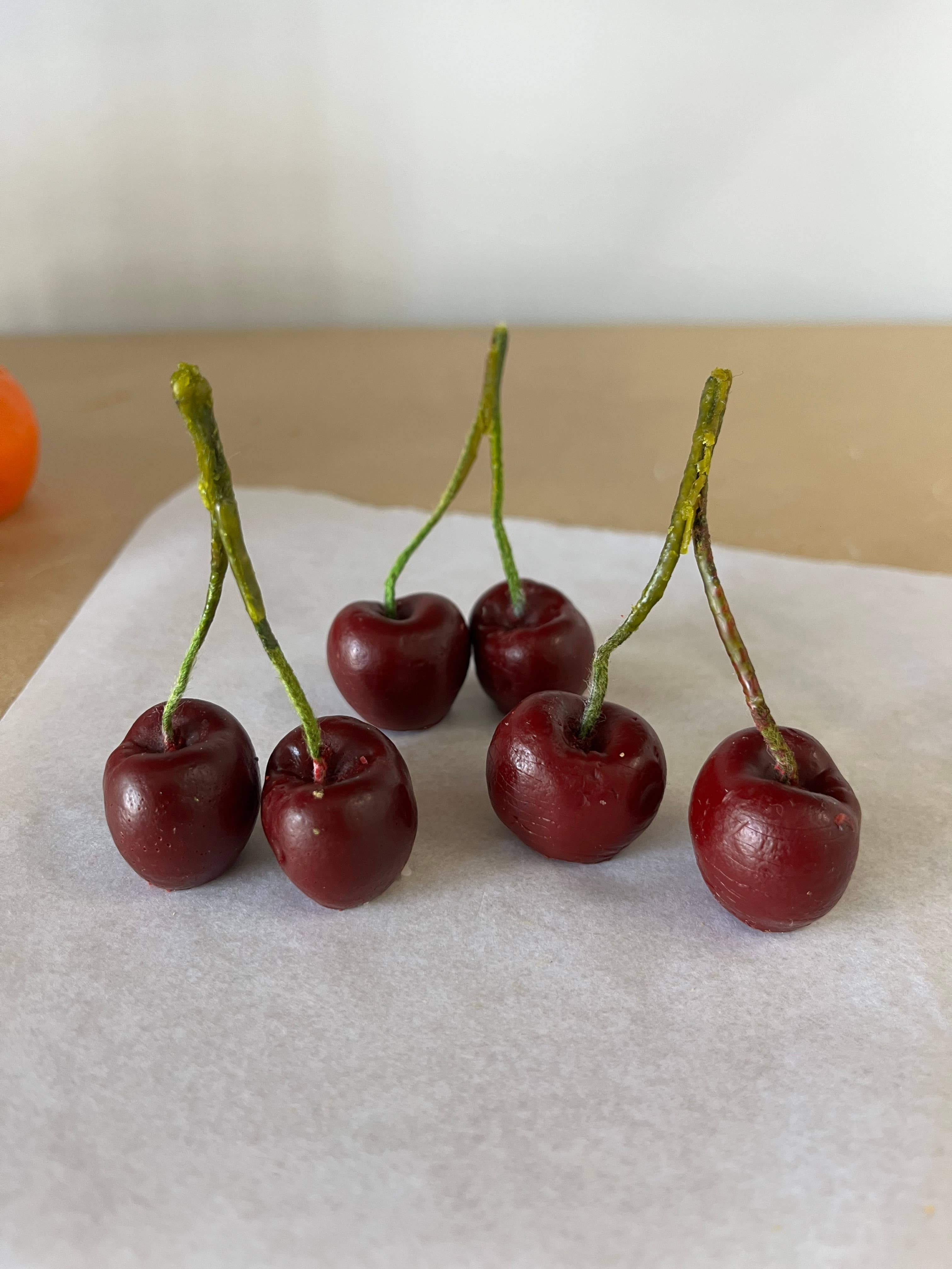 Handmade cherry-shaped candle crafted from 100% natural beeswax