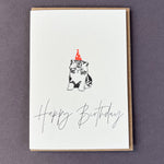 Happy Birthday letterpress greetings card featuring a grumpy kitten wearing a neon spotty party hat, designed by Penguin Ink.