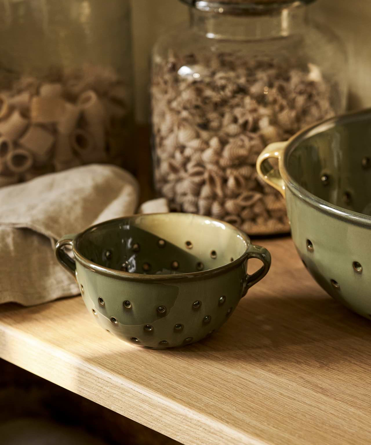 Ithaca Berry Bowl in Moss green stoneware with perforated sides and handles for rinsing and serving fresh fruit.