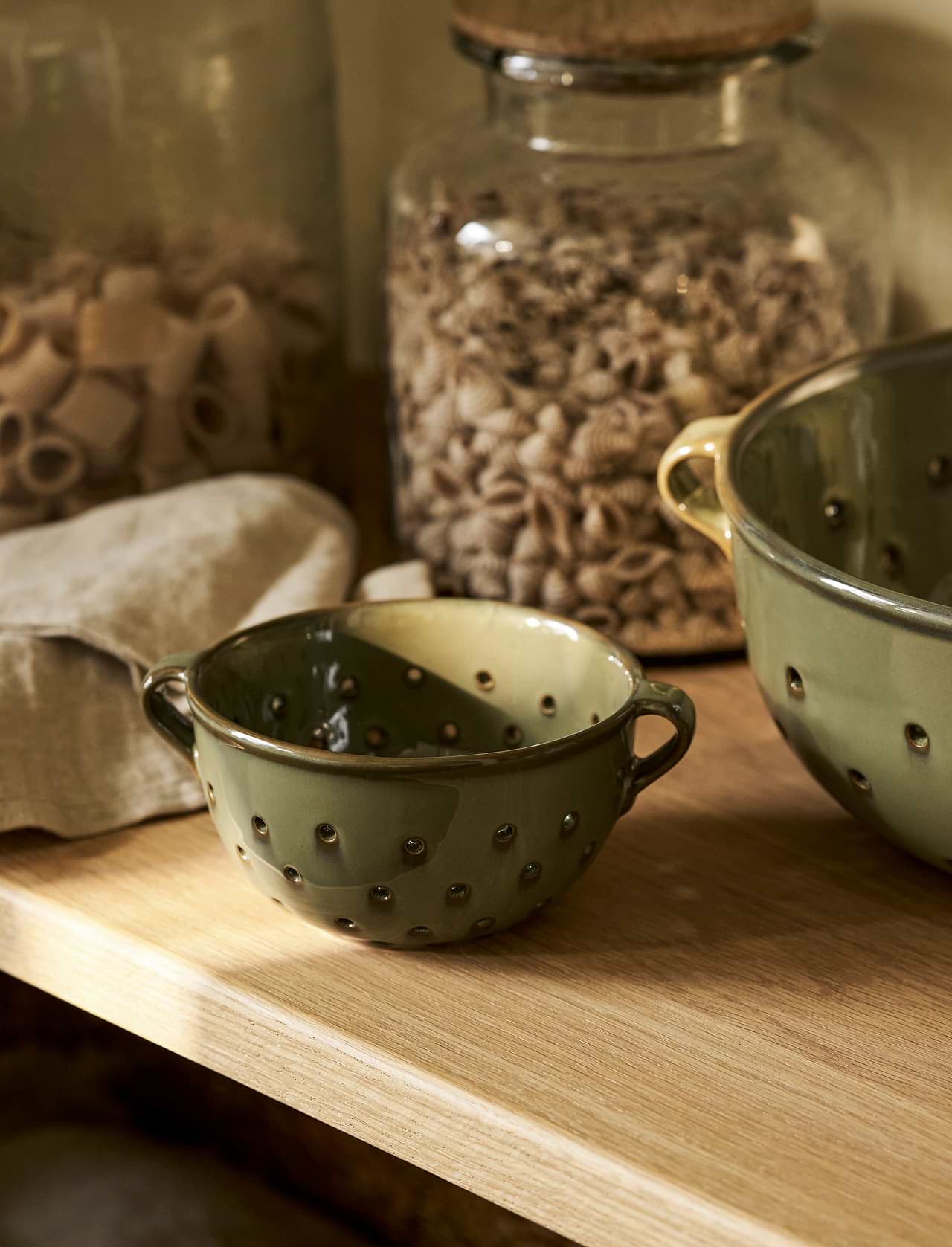 Ithaca Berry Bowl in Moss green stoneware with perforated sides and handles for rinsing and serving fresh fruit.