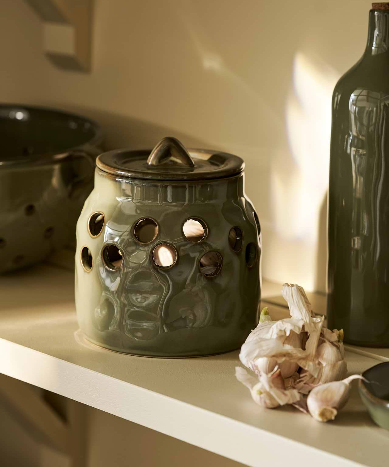 Moss green stoneware garlic storage pot with lid and ventilation holes