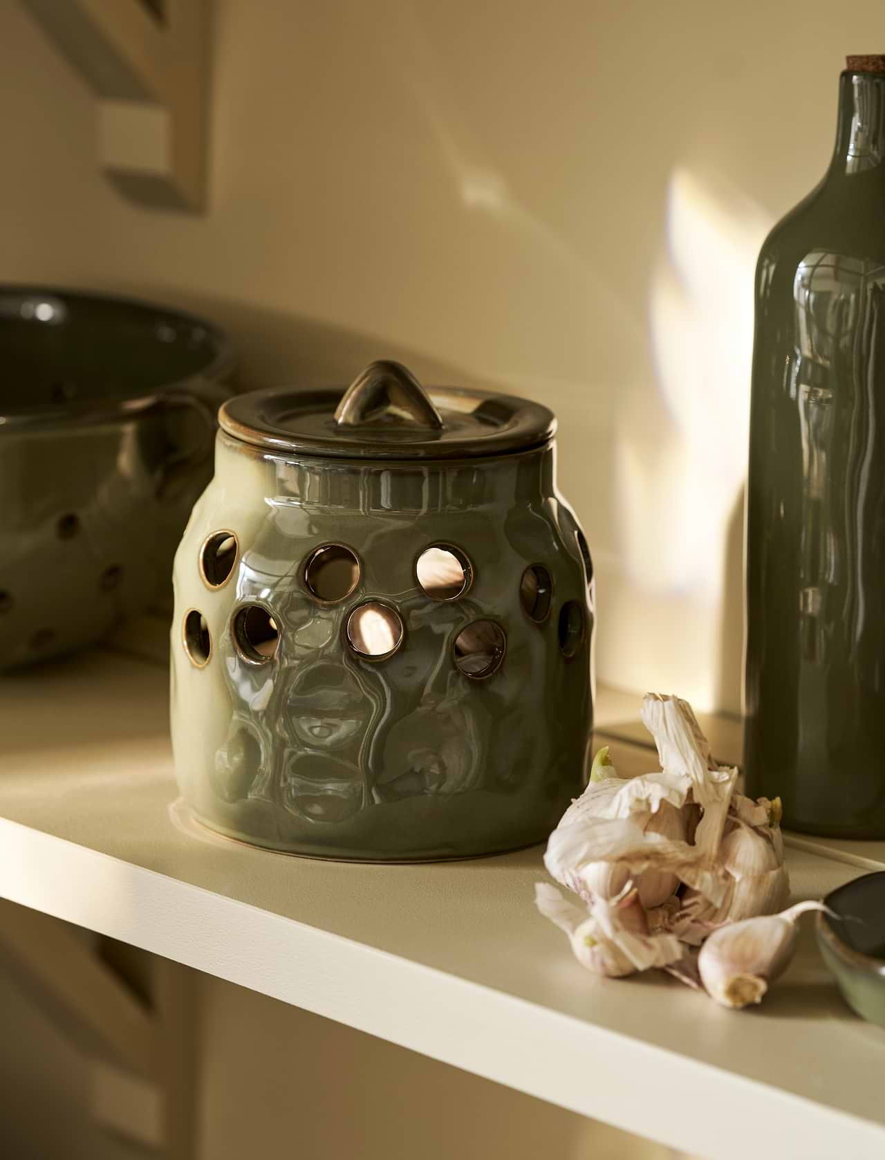 Moss green stoneware garlic storage pot with lid and ventilation holes