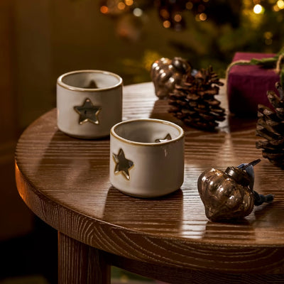 Pair of Ithaca white ceramic tealight holders designed to create a soft ambient candlelit glow.