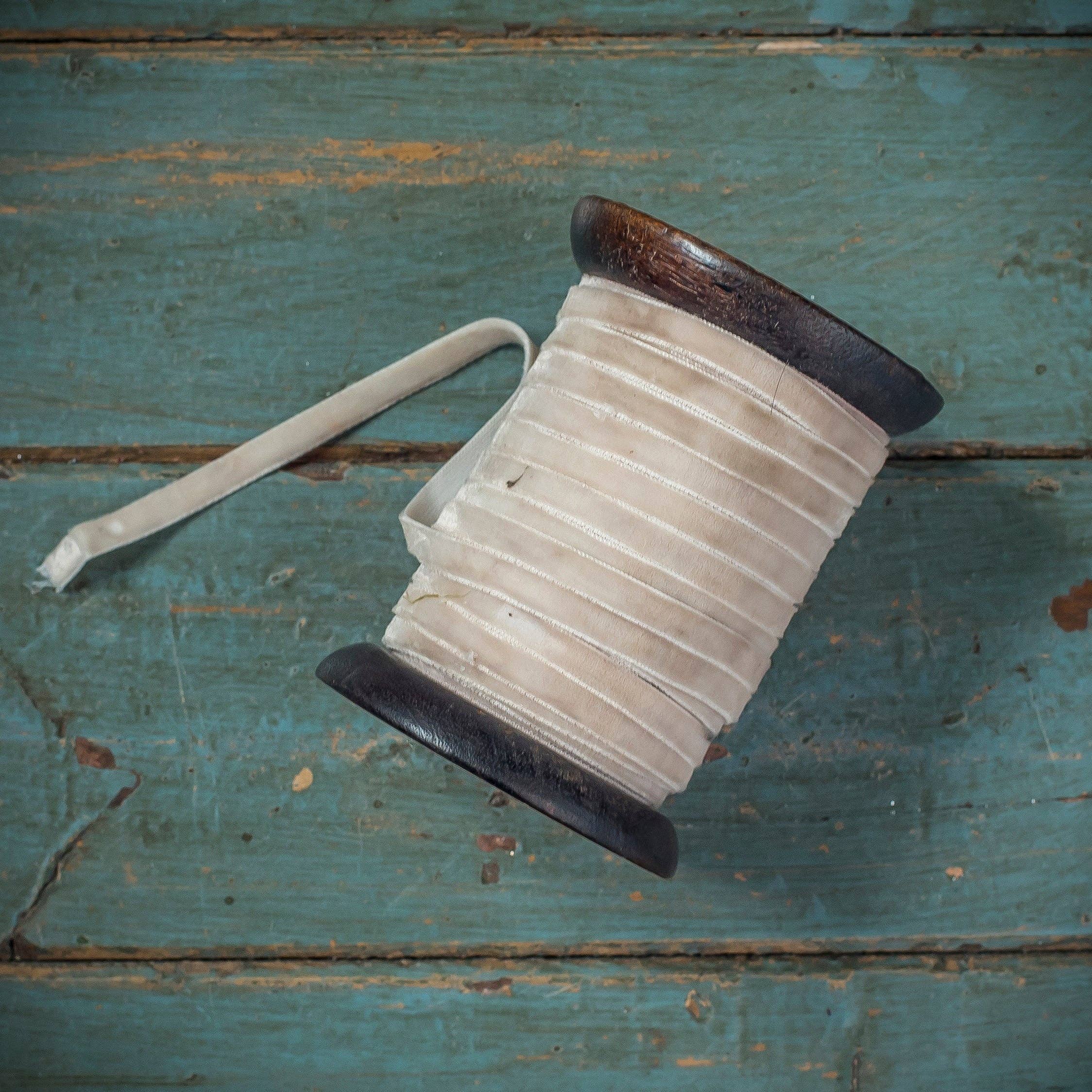 Soft ivory velvet ribbon for gift wrapping and crafting, available in 6mm and 10mm widths on a wooden spool or biscuit.