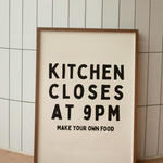 Framed poster with text 'Kitchen Closes at 9PM Make Your Own Food' against a tiled wall.