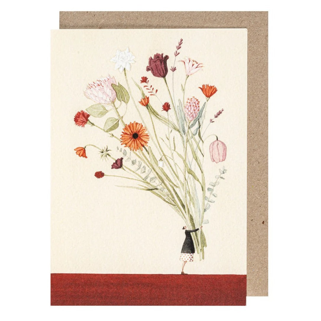 A greetings card featuring a colorful floral artwork and a small character, attached to a recycled kraft paper envelope.
