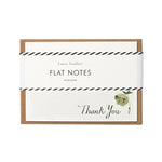 A flat note card with a 'Thank You' message, featuring a green hellebore design, enclosed in a clear bio-film packaging with a kraft paper envelope.