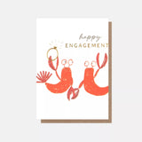 Happy Engagement card featuring two loving lobsters with an engagement ring and gold foil detailing.