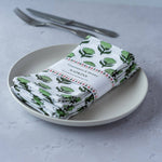 Hand block-printed Lotus Flower cotton napkins in soft modern colours styled on an elegant dining table.