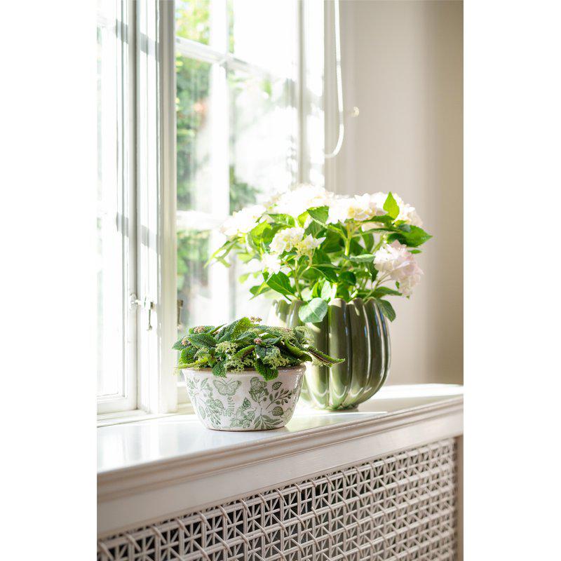 Green and white stoneware planter featuring foliage, fauna and butterfly motifs. A decorative plant pot perfect for houseplants and indoor styling.