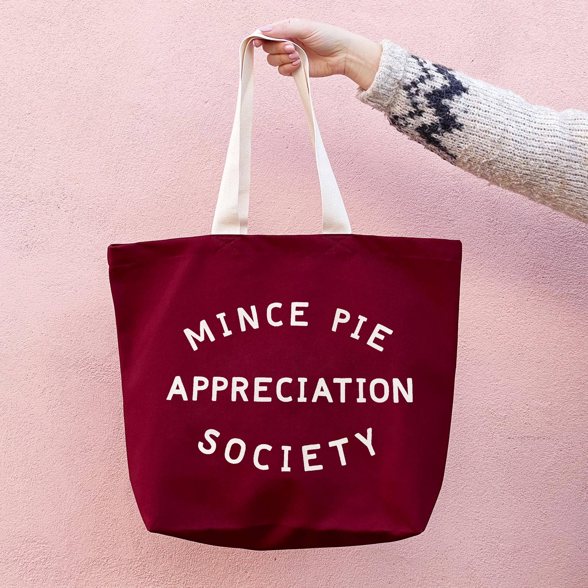 Burgundy canvas Christmas tote bag with off-white Mince Pie Appreciation Society illustration and sturdy carrying handles.