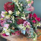October Bouquet of the Month with burgundy flowers, hot pink roses, snowberry, eryngium and eucalyptus