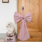Oversized Winter Berry gingham Christmas bow in deep berry pink and purple tones with matching hanging string.