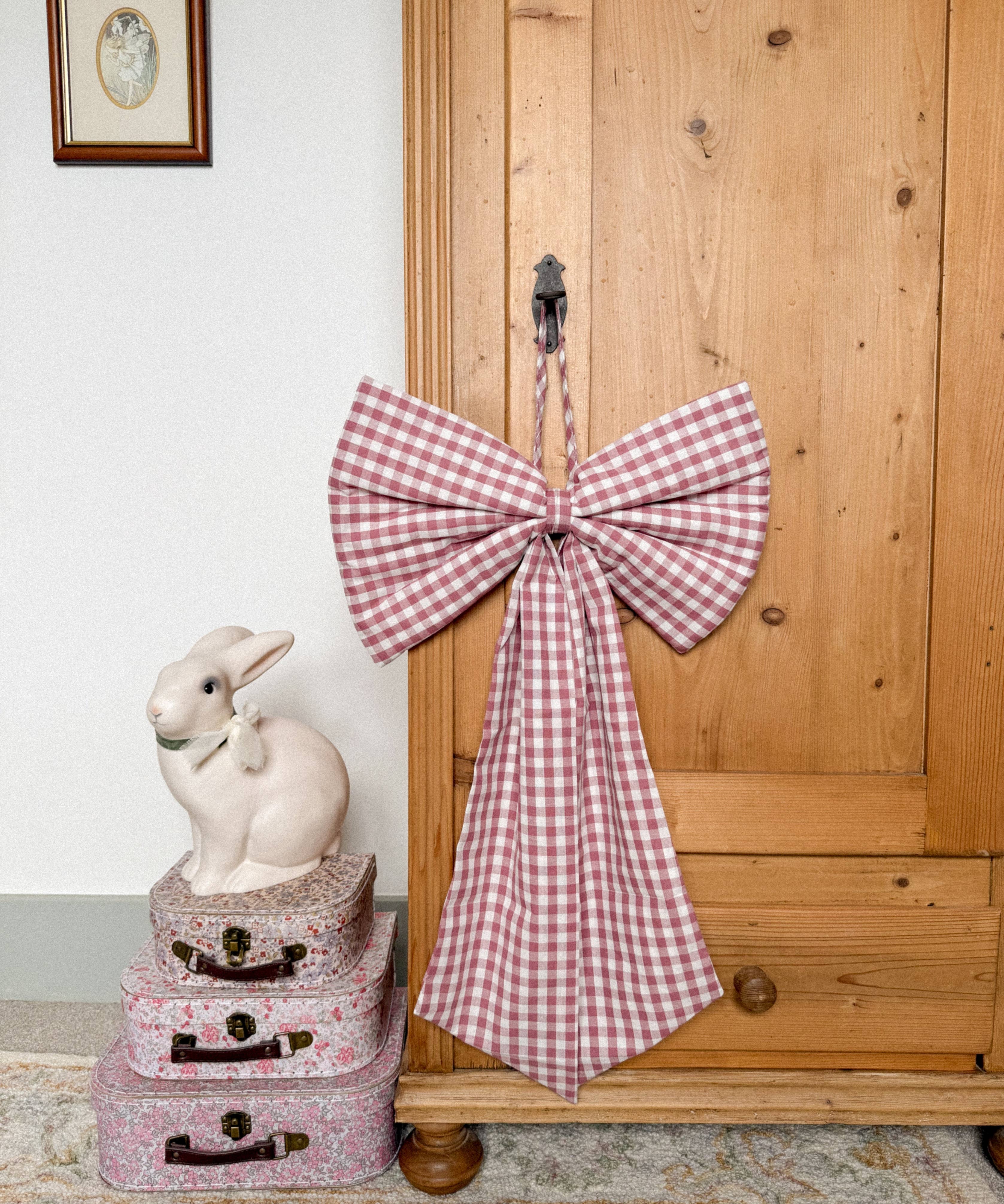 Oversized Winter Berry gingham Christmas bow in deep berry pink and purple tones with matching hanging string.