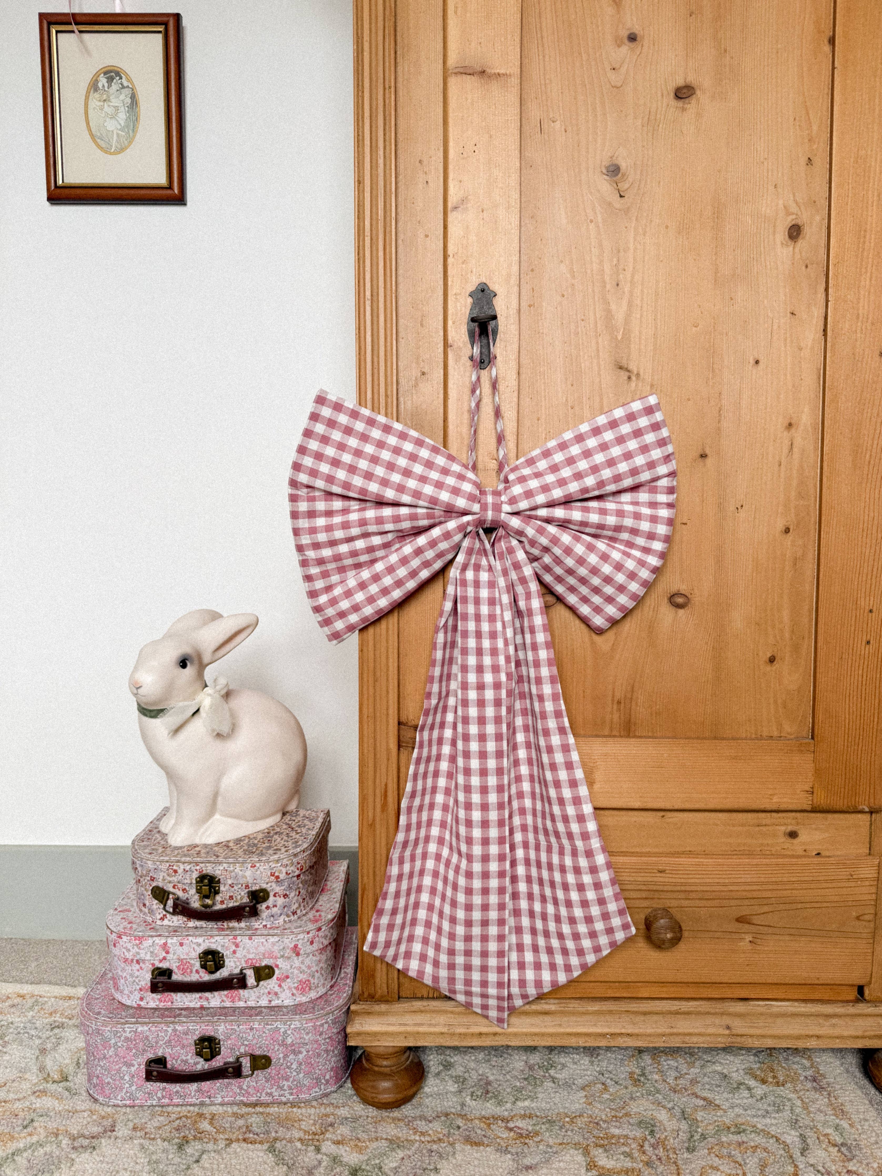 Oversized Winter Berry gingham Christmas bow in deep berry pink and purple tones with matching hanging string.