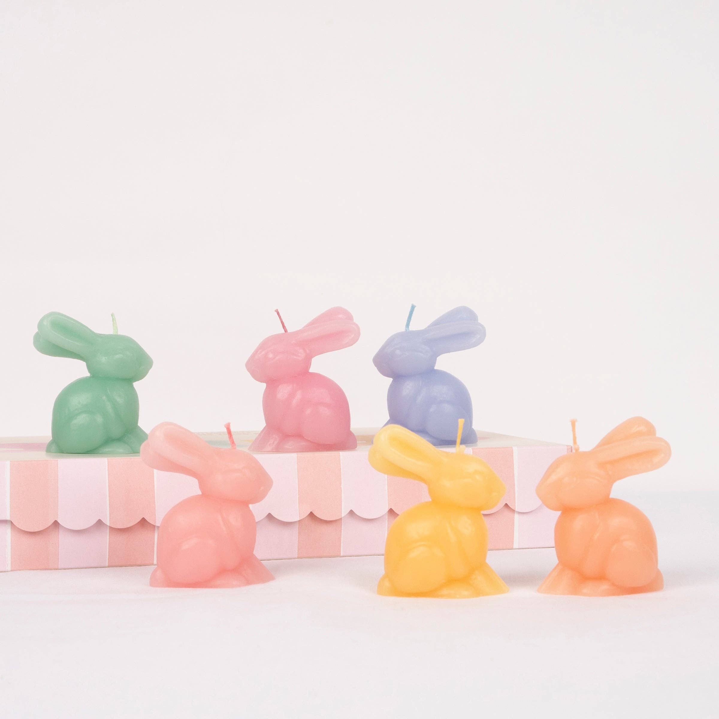 Set of six pastel bunny-shaped candles in pink, mint, peach, blue, lilac and yellow with matching coloured wicks.