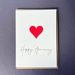 Penguin Ink Happy Anniversary Heart letterpress card featuring a red heart and elegant anniversary calligraphy, printed on 100% recycled board with a tactile embossed finish.
