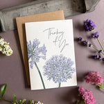 Penguin Ink Thinking of You floral letterpress greeting card featuring purple alliums and agapanthus, green stems and elegant modern calligraphy.