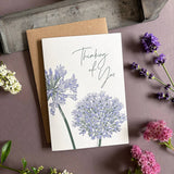 Penguin Ink Thinking of You floral letterpress greeting card featuring purple alliums and agapanthus, green stems and elegant modern calligraphy.