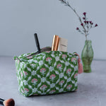 Petal hand block printed cotton cosmetic bag with floral pattern and waterproof lining for travel and beauty storage.