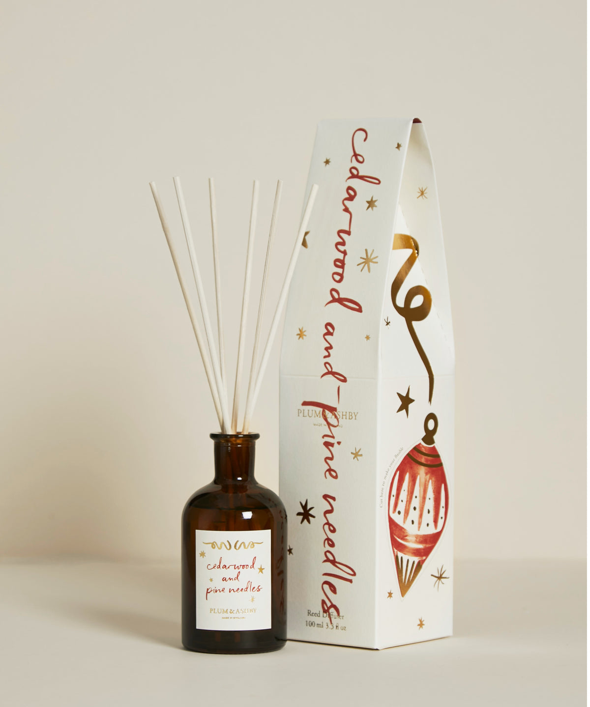 Plum & Ashby Cedarwood & Pine Needles 100ml Christmas reed diffuser in a recyclable glass vessel with illustrated festive gift packaging.