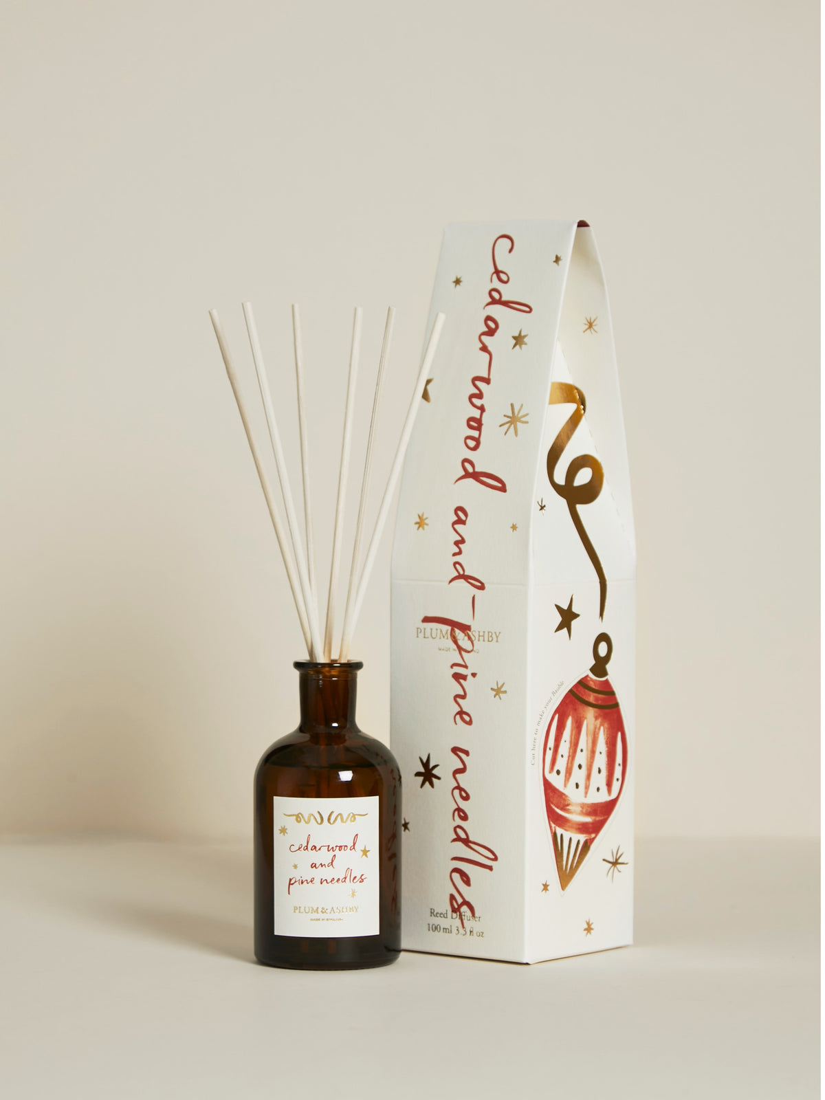 Plum & Ashby Cedarwood & Pine Needles 100ml Christmas reed diffuser in a recyclable glass vessel with illustrated festive gift packaging.