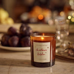 Plum & Ashby Christmas Kitchen Candle in Mulled Orange & Ginger fragrance, presented in amber glass with illustrated festive packaging.