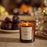 Plum & Ashby Christmas Kitchen Candle in Mulled Orange & Ginger fragrance, presented in amber glass with illustrated festive packaging.
