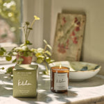 Plum & Ashby 'Kitchen' candle and packaging on a marble surface with plants and a bowl in the background.