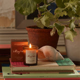 Plum & Ashby Sitting Room Votive Candle – Green Sandalwood & Fern in a recyclable glass vessel. A hand-poured natural soy wax candle with fresh violet leaf, lily of the valley, green sandalwood, vetiver and fern, designed to create a warm, calming living space.