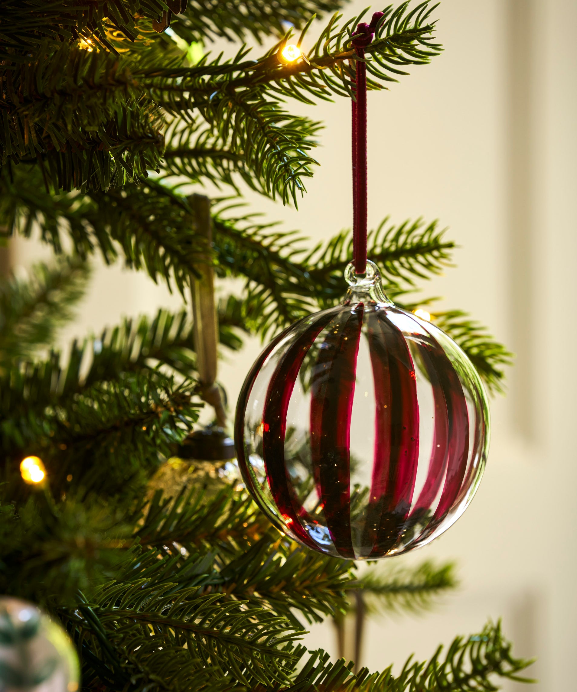Large clear glass Christmas baubles with hand-painted berry red and gold stripes and velvet ribbons