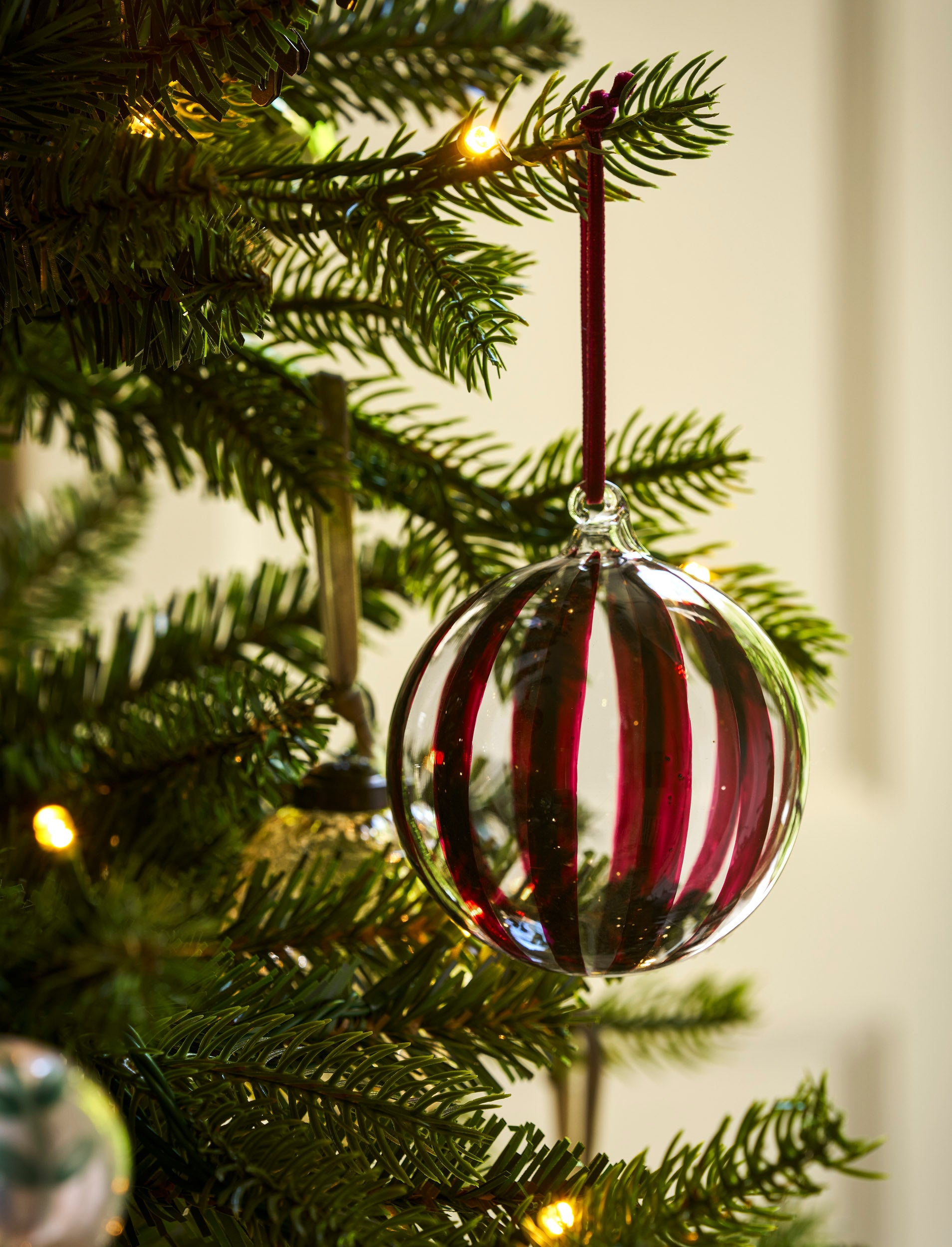 Large clear glass Christmas baubles with hand-painted berry red and gold stripes and velvet ribbons