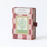 Roomytown Book of Herbs botanical playing cards featuring vintage herb illustrations and a pink check patterned reverse in a luxury gift box.
