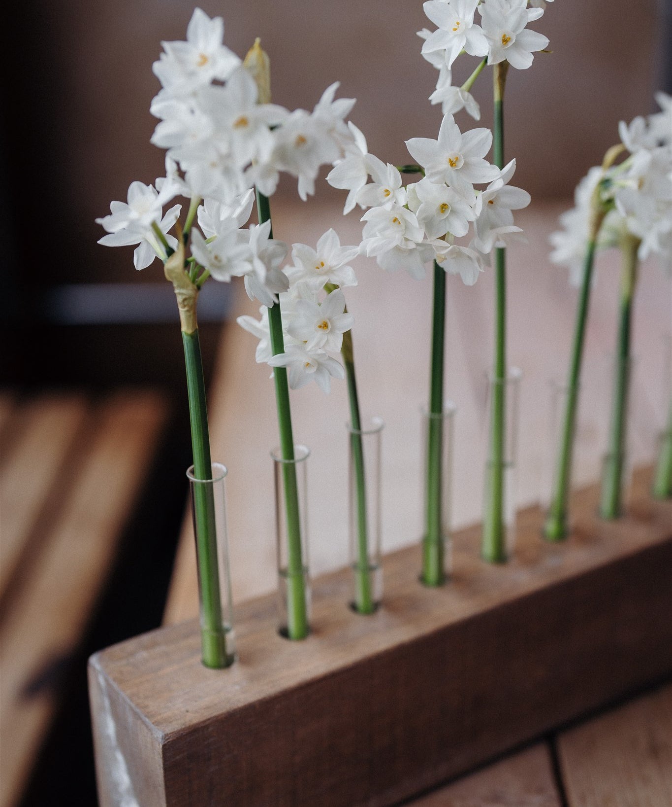 Handcrafted solid oak Flower Stem Keeper with individual glass tubes displaying fresh flower stems in a minimalist wooden vase.