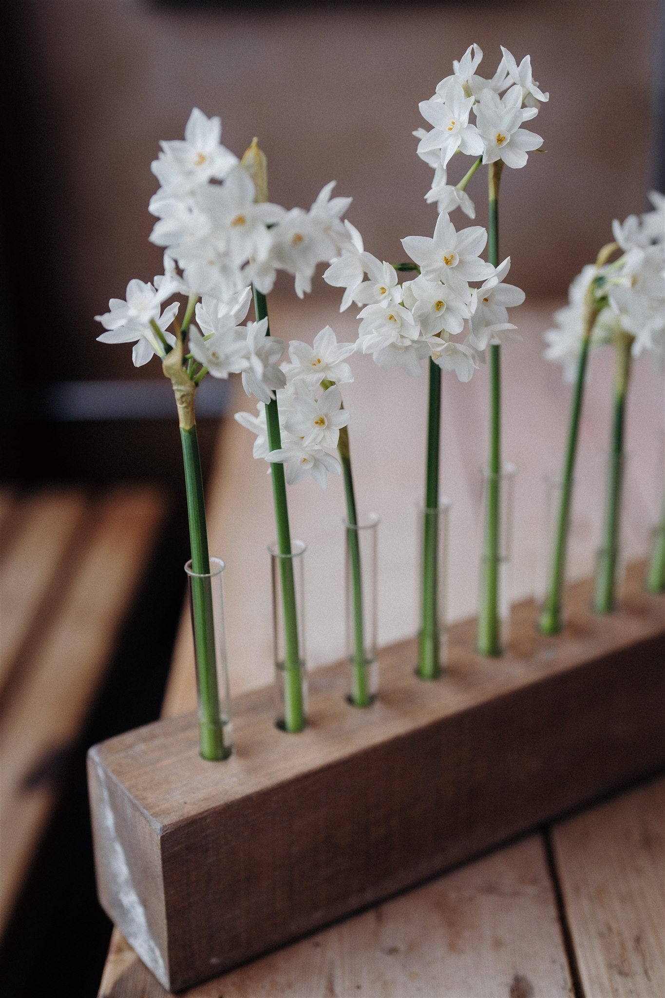 Handcrafted solid oak Flower Stem Keeper with individual glass tubes displaying fresh flower stems in a minimalist wooden vase.