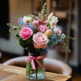 Seasonal flowers arranged in a reusable keepsake jar with natural garden-style flowers and foliage.
