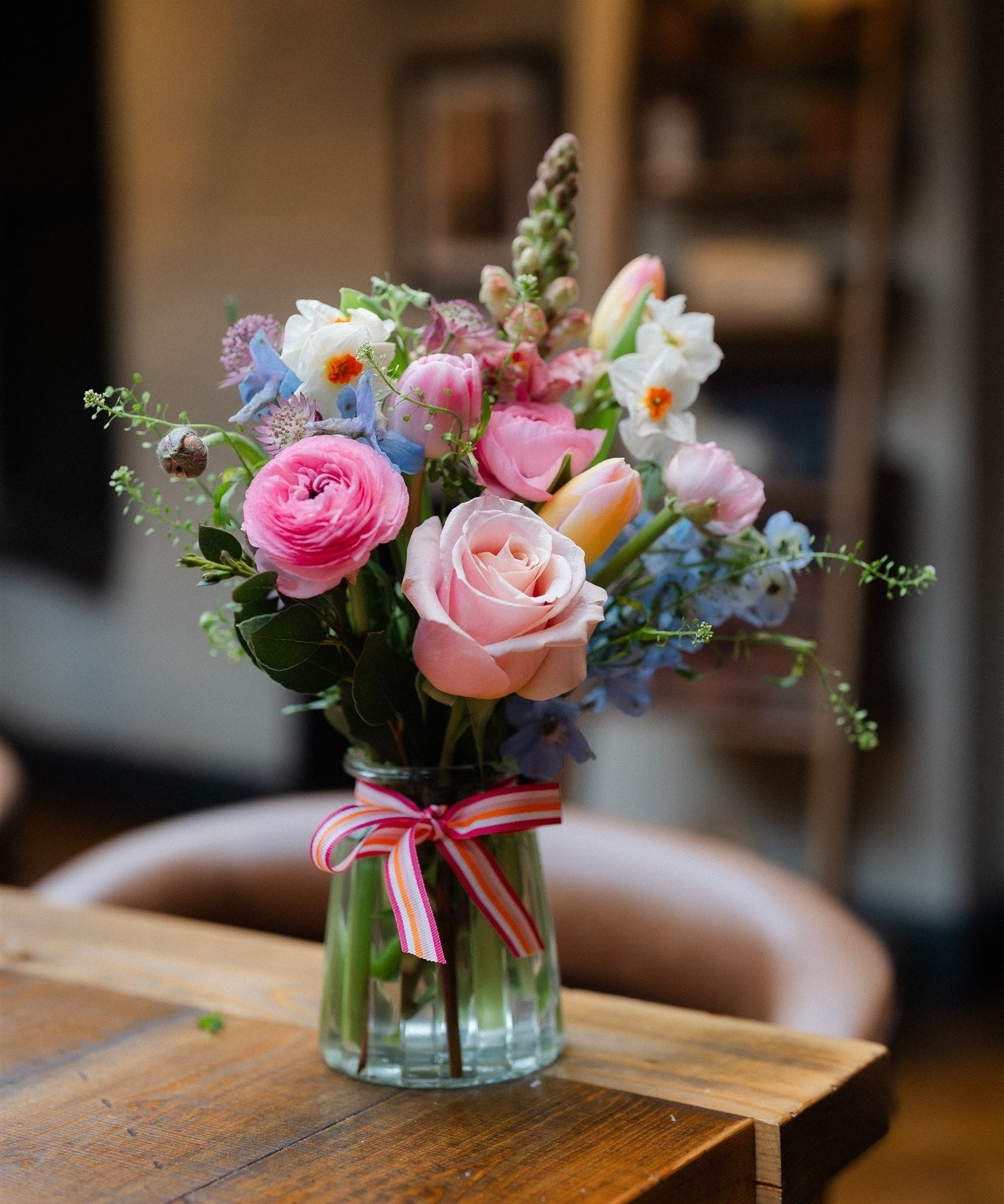 Seasonal flowers arranged in a reusable keepsake jar with natural garden-style flowers and foliage.